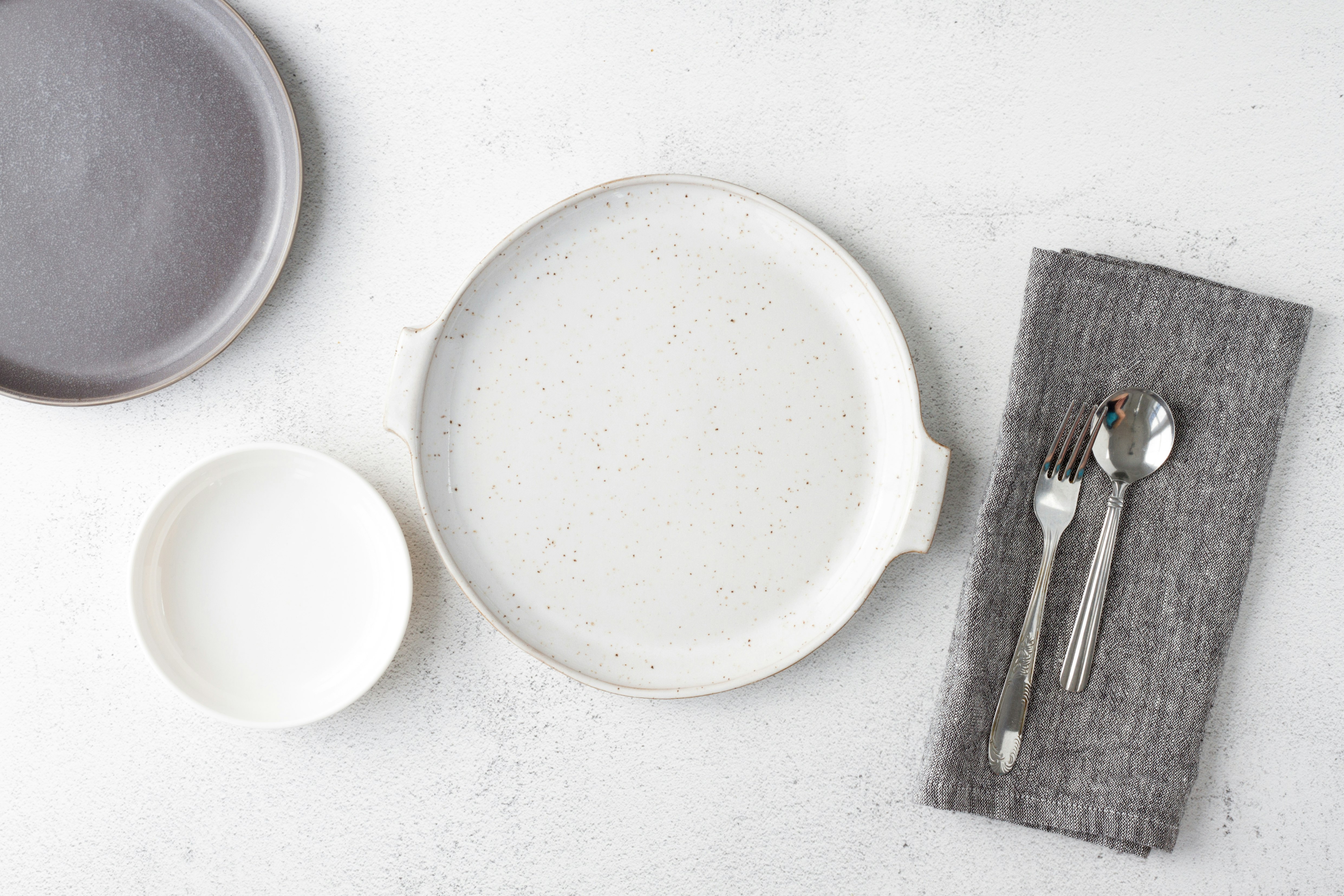 white round plate beside fork and bread knife